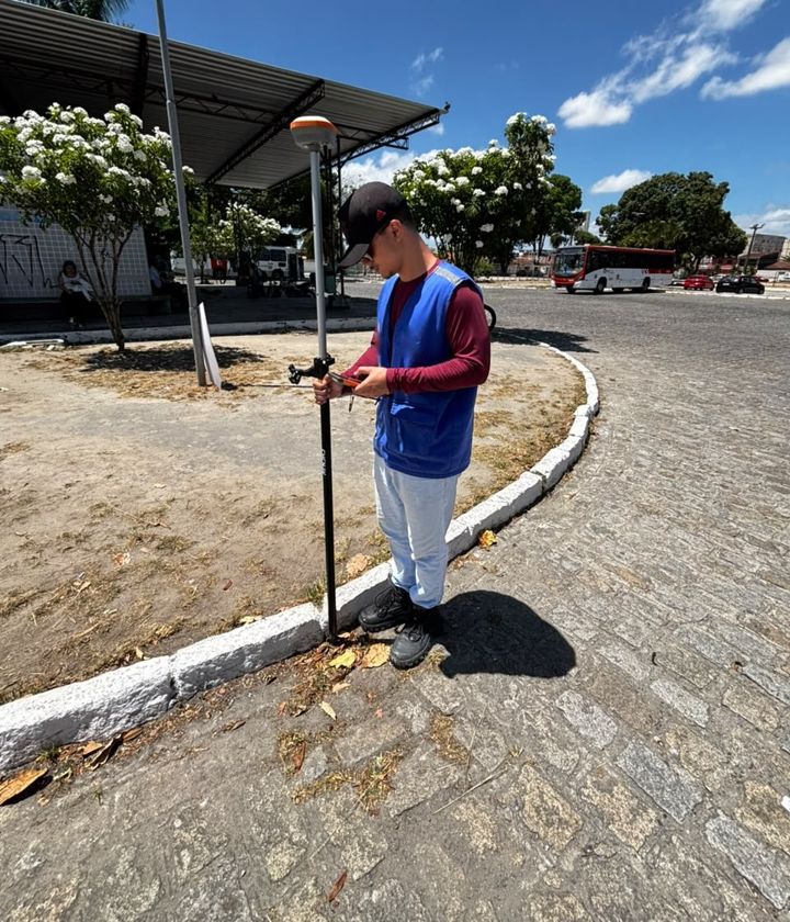 Membro da Nortear coletando pontos com receptor GNSS em uma praça